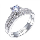 Knife Edge Cathedral Style Engagement Ring Featuring A Round Center Stone and Double Row of Stones on Each Band Plated in White Gold WS035