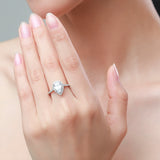 Pear and halo engagement ring with prong set pave side stones 