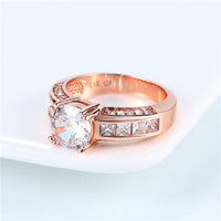 2 Carat Round Split Prong Engagement Ring Featuring Princess Cut Channel Set Side Stones and Round Surprise Stones on Side Profile Rose Gold Eng063
